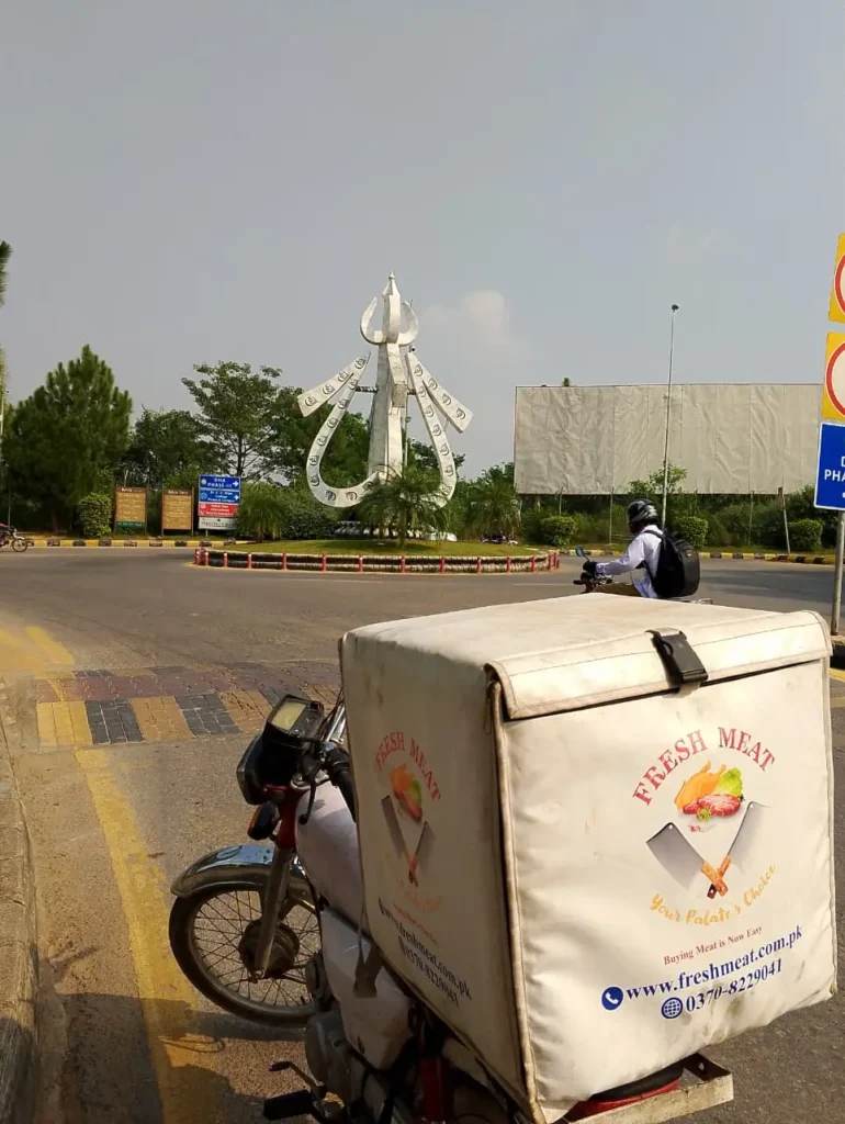 Fresh Meat Shop delivery bike at Allah Hu Chowk, Intellectual Village